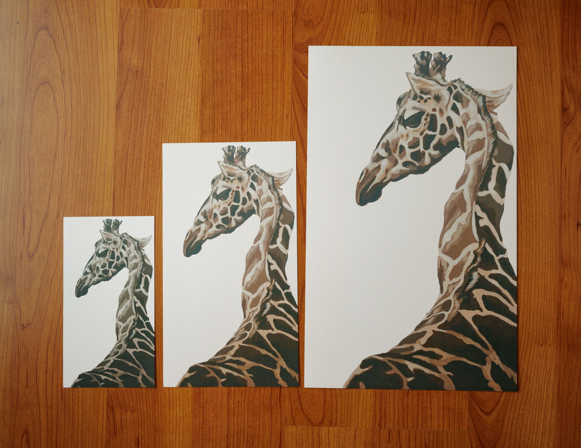 three sizes of prints of a brown and cream giraffe