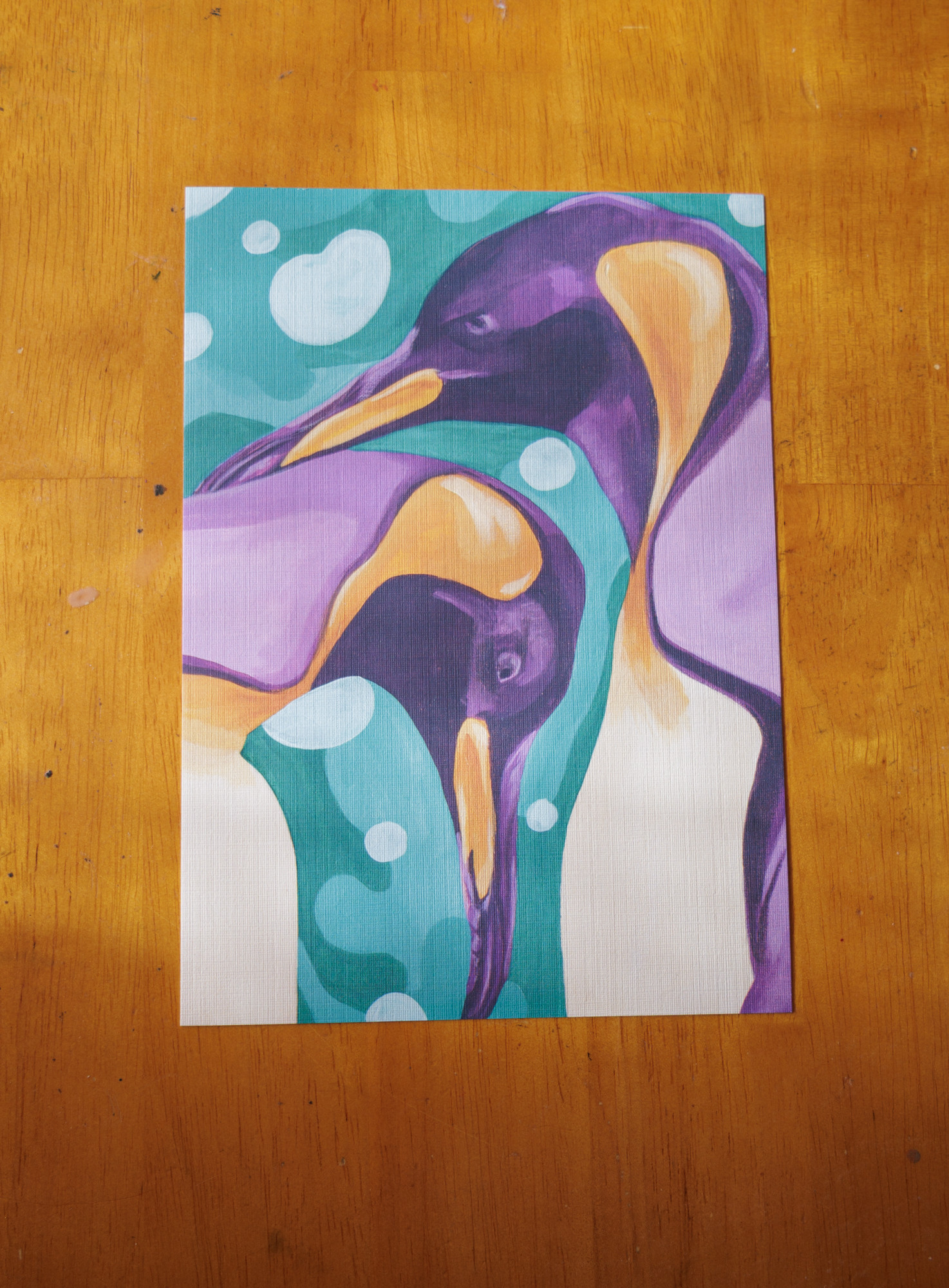 two purple and orange penguins in front of a blue, bubbly background