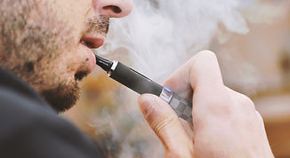 Un homme utilise une cigarette électronique.