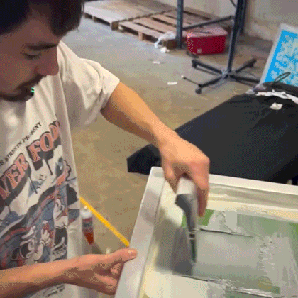 Footage of a screen printer manually printing neck tags