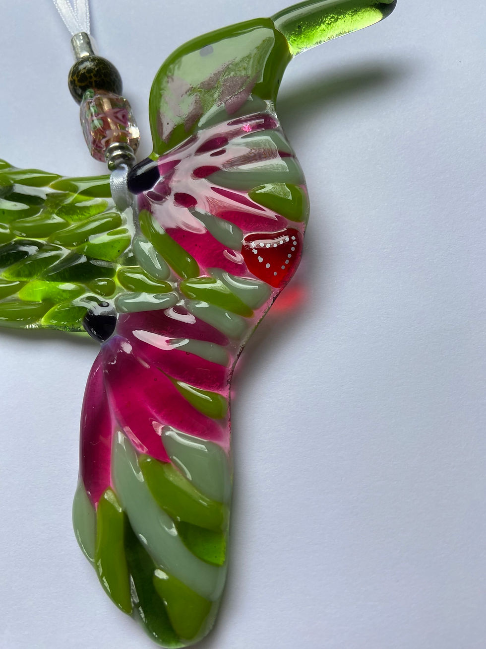 Thumbnail: hanging fused glass hummingbird with red heart and vibrant pink flower on its breast