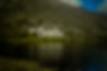 A grand castle sits beside a dark lake and mountain._edited.jpg