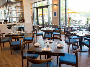 Interior dining room of Bar Mezzana Boston with soft lighting, open kitchen