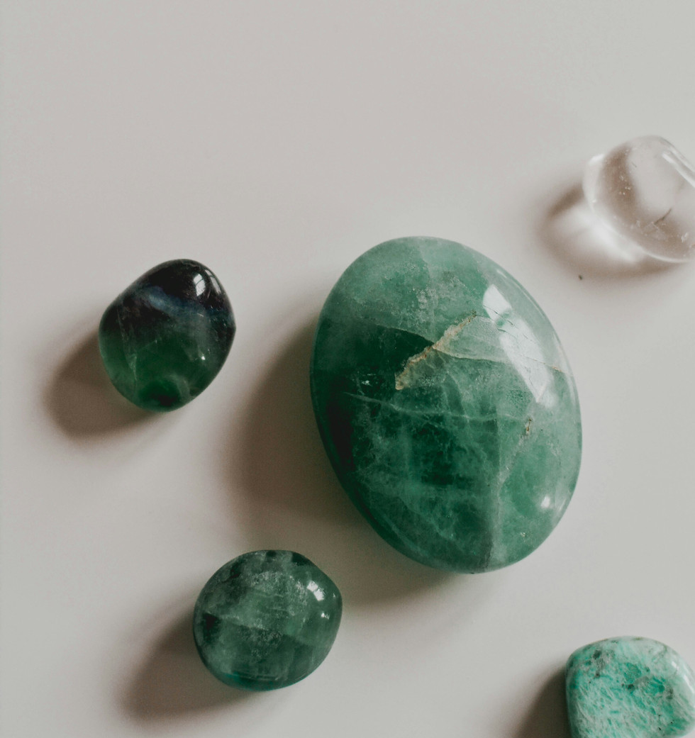 Smooth green fluorite crystals on a white surface.