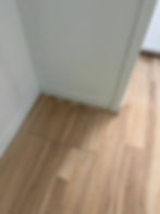 Flush-mount wooden floor vent in light oak flooring.