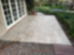Modern tiled patio next to white French doors