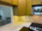 Mustard yellow kitchen cabinets and white marble counters