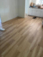 Polished light wood flooring in a renovated room.