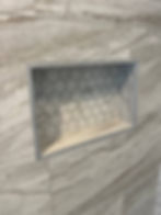 Hexagon tile shower niche in a marbled wall