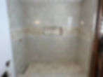 Modern walk-in shower with marble tiles and mosaic niche