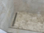 Walk-in shower with pebble tile floor and linear drain