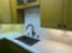 Olive green kitchen cabinets with matte black faucet