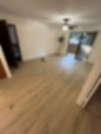 Empty room with light wood floors and ceiling fan.