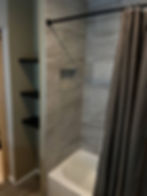 Modern tiled shower with bathtub and built-in shelving