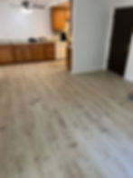 Modern light wood flooring in a kitchen and living area.