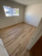 Bright empty room with light oak hardwood floors.