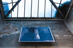 Large photo displayed on the wall of an art gallery, with the gallery's roof visible in the frame