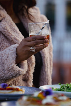 Hand holding a beverage in a glass at an event