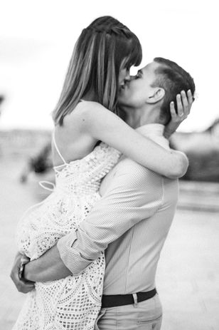 fekete-fehér jegyes kép ahogy a lány a fiú ölébe ugrik fel és csókot adnak egymásnak