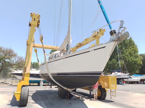 Grúa elevando velero blanco para mantenimiento