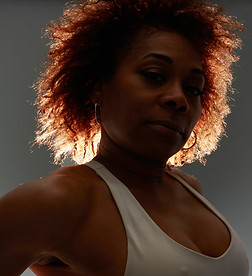 Orisha Re', founder of Fearless Re'volution, in a dramatic close-up portrait embodying sensual strength and fearless femininity