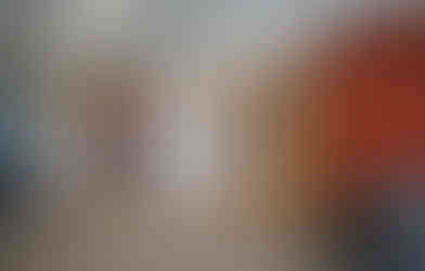 Woman sitting in lobby of new Queen Bee School District operations center, with view into round board room through interior windows