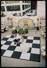 Bride and groom dancing on a rooftop dance floor.