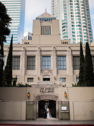 Wedding couple poses at the entrance of the Los Angeles Central Library.