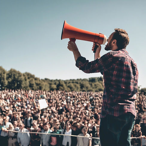 man using a megaphone up above talking to a crowd below him.jpg