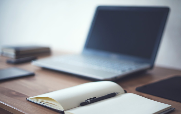 Laptop, book and pen on a desk. Waiting for the English lesson.