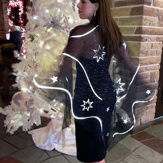 Model wearing elegant black poncho with 3M reflective design visible up to 1000 feet