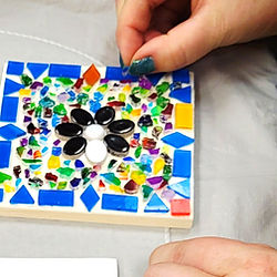 Main en train de créer une mosaïque.