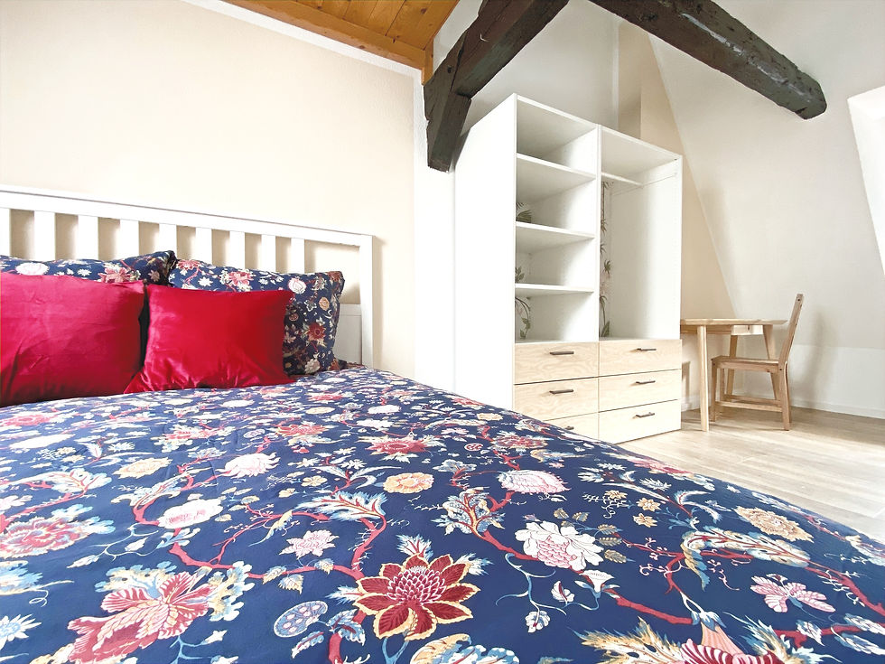 Großes Schlafzimmer mit Doppelbett und Arbeitsplatz