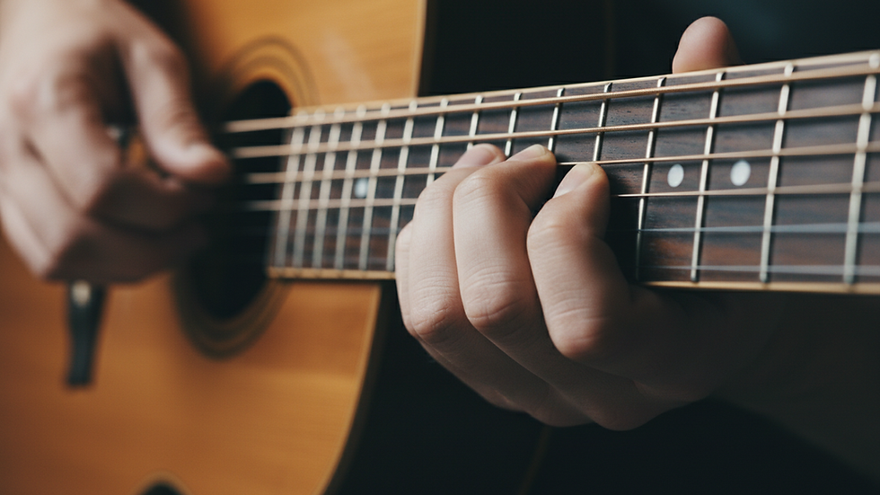Close-up view of guitar strings and fingers pressing chords
