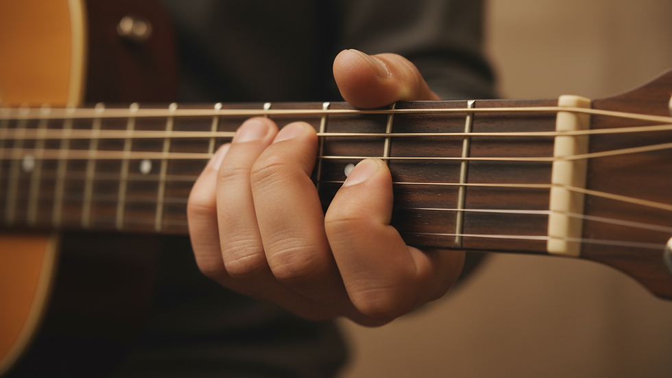 Close-up view of guitar fretboard showing finger placement on chords