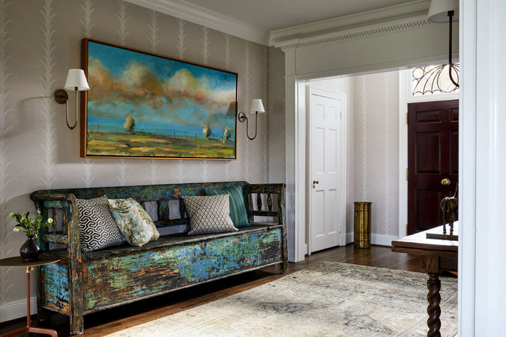 Antique bench and leaf-print wallpaper in a Warrenton, VA colonial entryway