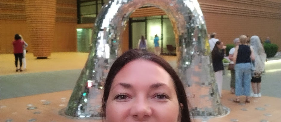 Empowerment Coach and Reiki Master Teacher Brooke Rowe at The Oneness Experience with Lee Harris and the Z's. Standing before a mirrored firebird sculpture, reflecting on self-trust, soul alignment, intuition, and spiritual growth.