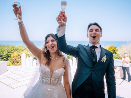 Sposi felici alzano i calici al cielo. Brindisi emozionante con gli invitati, enfatizzato dall'atmosfera sonora curata da Direzioni Parallele.