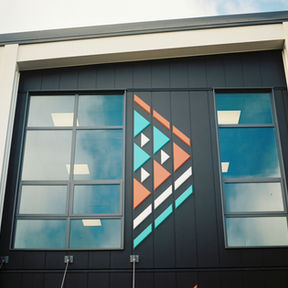 Tupua Horo Nuku cultural panels on Hutt Valley High School's C-Block — external Māori art by Len Hetet (Waiwhenua Design) telling the story of Ngāke and Whaitaitai