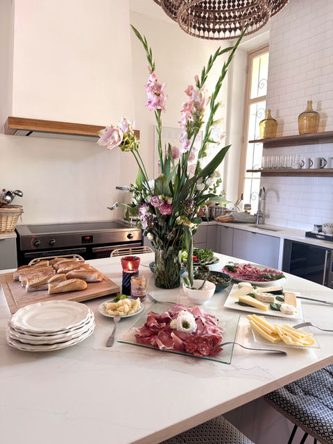 Bright kitchen island with bread, meat, flowers, accommodations South of France.