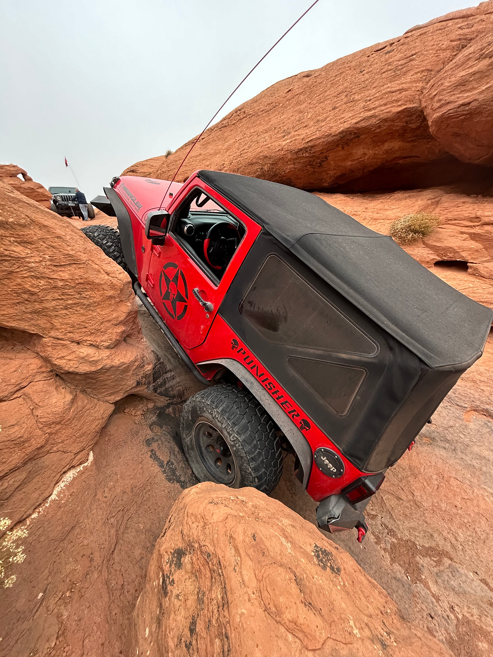 Eye-level view of a rugged 4x4 vehicle climbing a rocky trail in Southern Utah