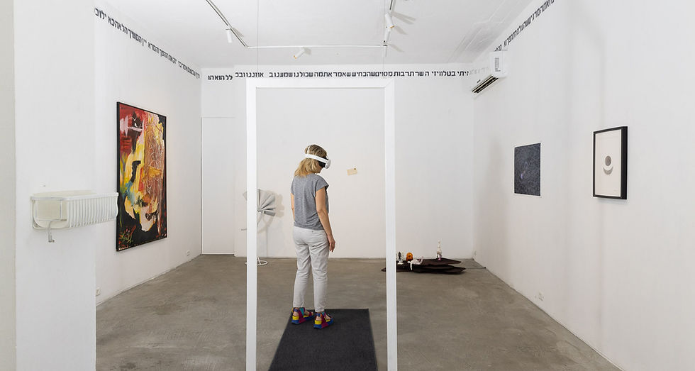 Interior of gallery. with paintings on the walls. White frame in center of picture. Woman standing with her back to us wearing VR glasses.