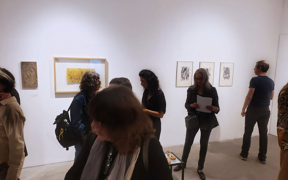 חלל גלריה בנימין, תמונות תלויות על הקיר ואנשים משוחחים בחלל