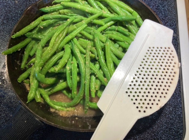 Drained excess liquid from cooked green beans with handy draining tool.