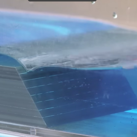 A submerged berm located parallel to shore in shallow water would prevent wave energy from impacting shore with so much force.