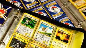 A collection of Japanese Pokémon trading cards is neatly organized in a binder.