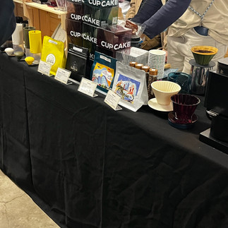 Assortment of coffee equipment and cups laid out across a black table