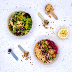 a square platter of salad bowls, proteins, sprinkles and measuring spoons