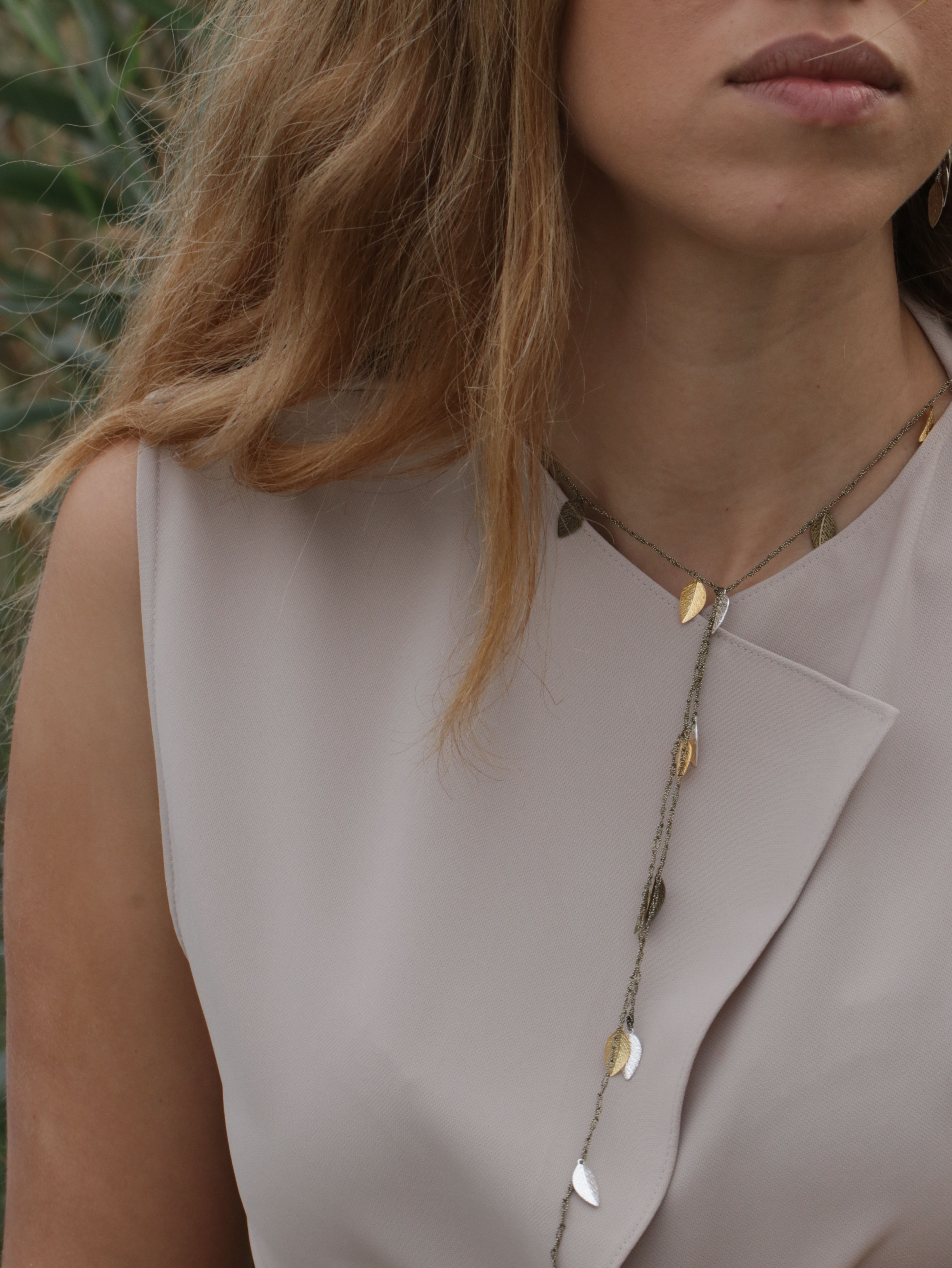 A model wears a handmade silk thread necklace with leaves