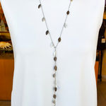Frontal view of a long hypoallergenic scarf necklace in silver silk with blackened leaves on a mannequin.